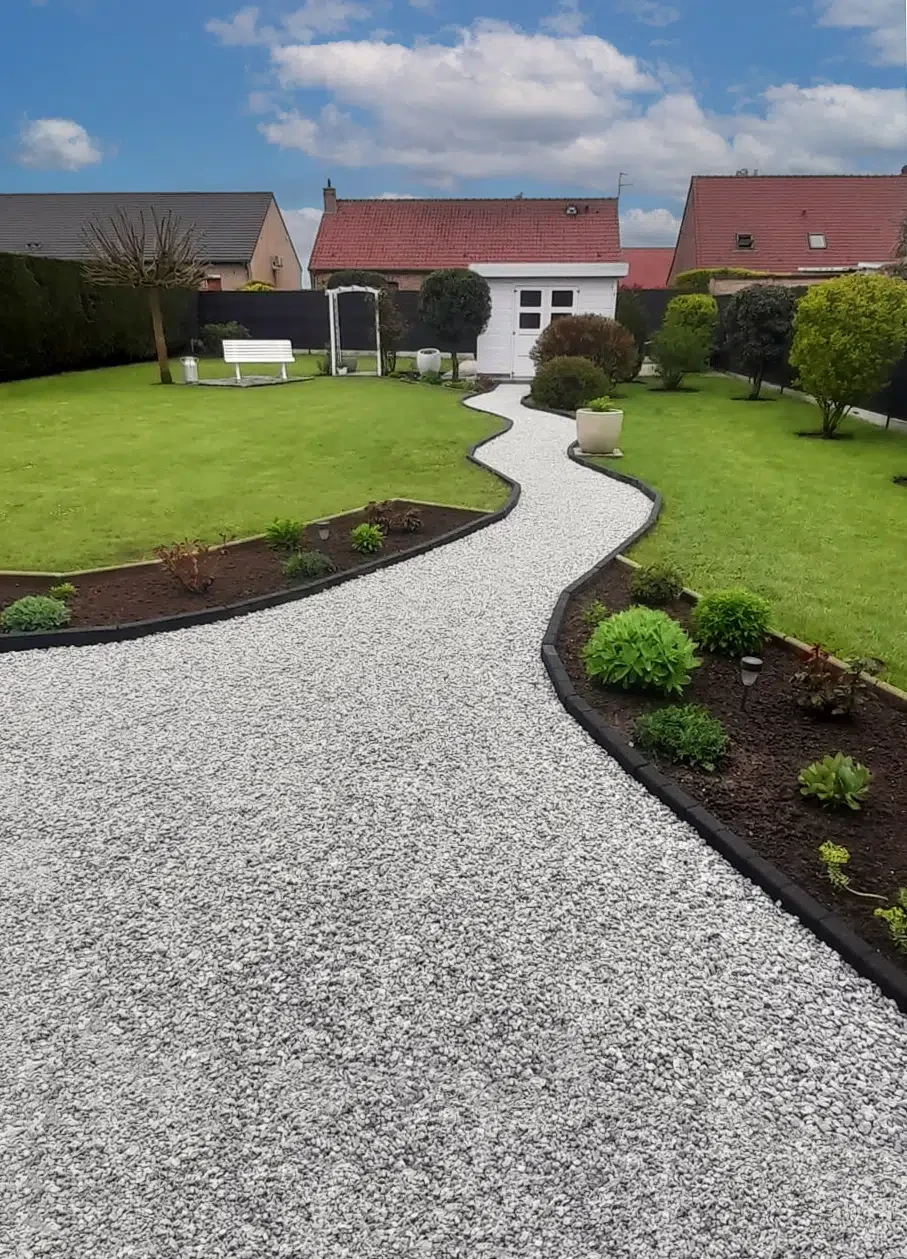 Jardin paysager avec fontaine sphérique en granit noir au centre d'un massif fleuri