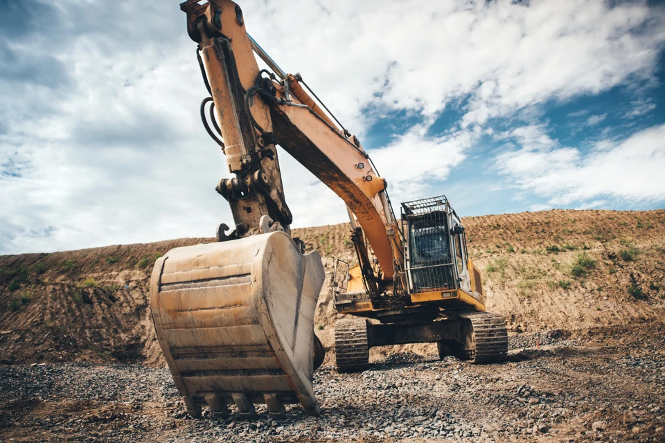 Chantier de terrassement en extérieur avec pelleteuse hydraulique sur chenilles en action